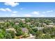Aerial view of a property with a manicured lawn, mature trees, and nearby shops at 1564 S Uinta Way, Denver, CO 80231