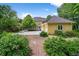 Backyard featuring the exterior of the house, a brick path, and green foliage at 1564 S Uinta Way, Denver, CO 80231