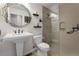 Bright bathroom featuring a pedestal sink, decorative mirror, toilet, and glass enclosed shower at 1564 S Uinta Way, Denver, CO 80231