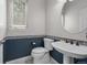 Half bathroom featuring a pedestal sink with bronze fixtures, decorative tile and white toilet at 1564 S Uinta Way, Denver, CO 80231