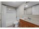 Bathroom with a shower-tub combo, vanity with wood cabinets, and ample mirror for grooming at 1564 S Uinta Way, Denver, CO 80231