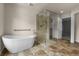 Luxurious bathroom featuring a soaking tub, walk-in glass shower, and tile flooring at 1564 S Uinta Way, Denver, CO 80231