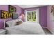 Bedroom with purple walls features a white bed, and large window overlooking a backyard at 1564 S Uinta Way, Denver, CO 80231