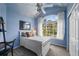 Light blue bedroom features whimsical painted clouds, large window, and neutral carpeting at 1564 S Uinta Way, Denver, CO 80231