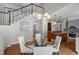 Bright dining area with a glass table adjacent to an open staircase and a view into the kitchen at 1564 S Uinta Way, Denver, CO 80231