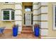 Inviting front porch with tiled floors, planters, decorative pillars, and bay window at 1564 S Uinta Way, Denver, CO 80231
