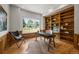 Well-lit office features hardwood floors, wood paneled walls, built-in shelves, and a large window overlooking the yard at 1564 S Uinta Way, Denver, CO 80231