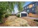 Spacious backyard with a detached garage, mulch ground cover, and a garden plot at 1736 Grove St, Denver, CO 80204