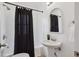 Updated bathroom featuring pedestal sink, decorative mirror, and shower with black curtain at 1736 Grove St, Denver, CO 80204