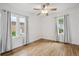 Empty bedroom with hardwood floors, ceiling fan, and natural light from large windows at 1736 Grove St, Denver, CO 80204