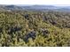 Aerial view of home, nestled among trees, showcasing its private and serene wooded setting at 2873 Cortina Ln, Evergreen, CO 80439