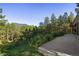 Tranquil backyard with mountain and forest views, a stone patio, and a metal fence at 2873 Cortina Ln, Evergreen, CO 80439
