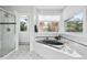 Serene bathroom with a modern soaking tub, shower, and large windows providing picturesque forest views at 2873 Cortina Ln, Evergreen, CO 80439