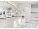 Bright bathroom featuring dual sinks, white cabinets, updated lighting, and a separate shower and soaking tub at 2873 Cortina Ln, Evergreen, CO 80439