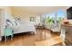 Sunlit main bedroom with hardwood floors, a large window with forest views, and a comfortable upholstered chair at 2873 Cortina Ln, Evergreen, CO 80439