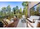 Inviting outdoor deck space with comfortable seating and views of mature trees and natural landscape at 2873 Cortina Ln, Evergreen, CO 80439
