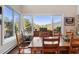 Bright dining room with scenic views, featuring a large window and a stylish wooden dining set at 2873 Cortina Ln, Evergreen, CO 80439