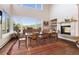 Sun-filled dining room with a fireplace, hardwood floors, and large windows with scenic views at 2873 Cortina Ln, Evergreen, CO 80439