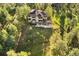 Back of house with a spacious deck, patio, and fenced yard blending into a lush forest at 2873 Cortina Ln, Evergreen, CO 80439