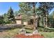 Inviting home with a two-car garage, lush landscaping, and mature trees on a well-maintained property at 2873 Cortina Ln, Evergreen, CO 80439