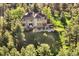 View of home with many windows, deck, and fenced yard among mature trees at 2873 Cortina Ln, Evergreen, CO 80439