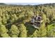 Stunning home featuring a large deck nestled among towering trees and natural surroundings at 2873 Cortina Ln, Evergreen, CO 80439