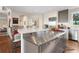 Kitchen island with stainless steel appliances and marble countertops complemented by bar seating and open floorplan at 2873 Cortina Ln, Evergreen, CO 80439