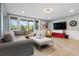 Cozy living room featuring a large sofa, natural light, wall-mounted TV and mountain views at 2873 Cortina Ln, Evergreen, CO 80439