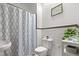 Bright bathroom with a decorative shower curtain, toilet, and modern sink at 3725 Federal Blvd, Denver, CO 80211