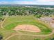 An aerial view shows a green park with a baseball field, walking path, and neighborhood in the background at 13246 Deneb Dr, Lone Tree, CO 80124