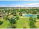 Aerial view featuring a playground and tennis courts surrounded by green lawns, trees, and community features at 13246 Deneb Dr, Lone Tree, CO 80124