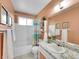 Cozy bathroom with tub, shower, toilet, marble sink, and peach walls at 13246 Deneb Dr, Lone Tree, CO 80124