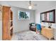 Bright bedroom featuring wood floors, ceiling fan, wooden shelf, sitting chair, desk and colorful rug at 13246 Deneb Dr, Lone Tree, CO 80124