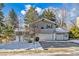 Two-story house with attached garage, landscaping, and snowy yard at 7169 S Marshall St, Littleton, CO 80128