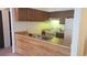 View of kitchen area with dark cabinets and standard appliances at 14806 E 2Nd Ave Ave # 105G, Aurora, CO 80011