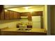 Efficient kitchen with wooden cabinets, white appliances, and a double sink at 14806 E 2Nd Ave Ave # 105G, Aurora, CO 80011