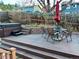 Outdoor deck with hot tub, dining table, red umbrella, and chairs, perfect for entertaining and relaxation at 26212 Center Dr, Kittredge, CO 80457