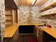 Finished basement wet bar features stone accents, wood shelving, and sink area at 26212 Center Dr, Kittredge, CO 80457