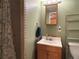 Bathroom with a wooden vanity, shower with patterned curtain, and green walls at 26212 Center Dr, Kittredge, CO 80457