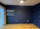 Calming bedroom with custom blue accent wall, light hardwood flooring, and bright window at 26212 Center Dr, Kittredge, CO 80457
