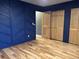 A view of a bedroom with custom accent wall, closet, hardwood floors, and neutral paint at 26212 Center Dr, Kittredge, CO 80457