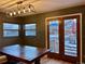 Dining area with rustic table, modern light fixture, and views of the outdoor patio at 26212 Center Dr, Kittredge, CO 80457