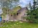 Charming home featuring a tidy lawn, wood fence, and rustic stone accents around the lower level at 26212 Center Dr, Kittredge, CO 80457