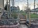 Landscaped front yard featuring stone stairs, fence, and mature trees leading up to the house at 26212 Center Dr, Kittredge, CO 80457