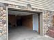 Open garage featuring a wood-paneled interior, ample storage, and stone exterior accents at 26212 Center Dr, Kittredge, CO 80457