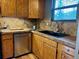Traditional kitchen featuring wood cabinetry, stainless steel appliances, and tile backsplash at 26212 Center Dr, Kittredge, CO 80457