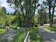 Picturesque park with a walking path alongside a gentle stream, shaded by lush greenery and mature trees at 26212 Center Dr, Kittredge, CO 80457