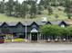 Rustic restaurant exterior featuring an American flag, dark wood siding, and beautiful floral arrangements at 26212 Center Dr, Kittredge, CO 80457