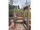 Stone steps and gated entrance leading to a grassy yard and lush landscaping at 26212 Center Dr, Kittredge, CO 80457
