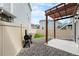 Backyard with wooden pergola, rock ground cover, fenced yard, and small grassy section at 3934 N Quatar Ct, Aurora, CO 80019